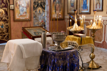 metal font for christening in the church with candles