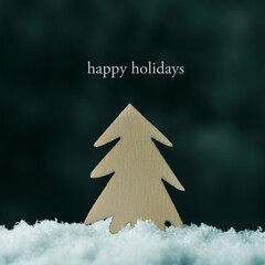 Fototapeta premium fir tree on the snow and text happy holidays