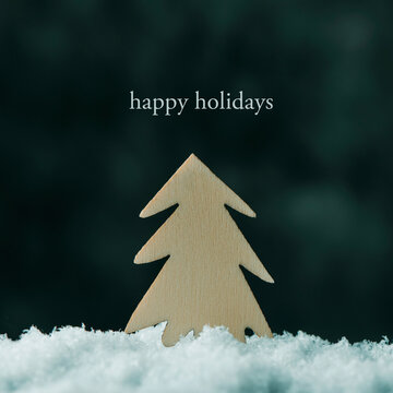 fir tree on the snow and text happy holidays