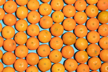 Juicy and healthy mandarins, messy, on a blue background, forming a pop art style texture