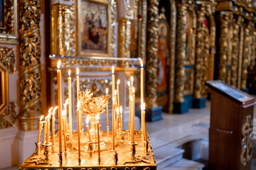 yellow burning candles in an orthodox church with a beautiful interior
