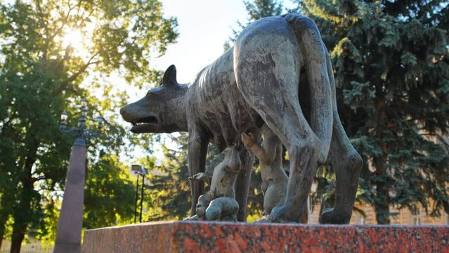 Close view of the Capitoline Wolf monument in Chisinau. National History Museum of Moldova and green trees on the background