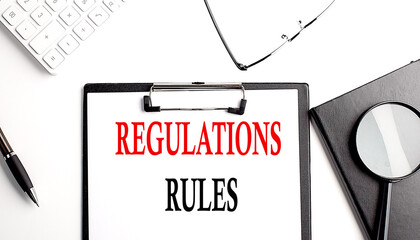 REGULATIONS RULES text written on paper clipboard with office tools