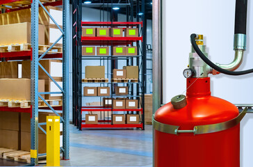 Fire safety equipment. Big red fire extinguisher inside warehouse. Storage room with large fire...