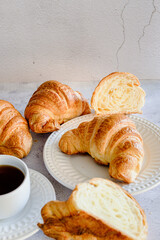 Broken croissant a cup of coffee and French breakfast white background. Space for text