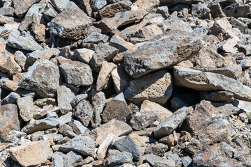 Large stones with sharp edges on the side of the mountain.
