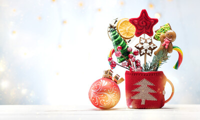 Festive banner Christmas gingerbread and candy on sticks in a red cup. Merry christmas card with sweets and decorations, copy space for text