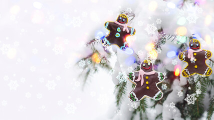 Christmas concept with gingerbread men on the background of a defocused Christmas tree and bokeh