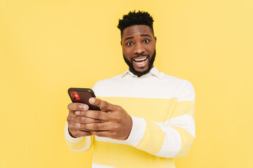 Black excited man using cellphone and screaming