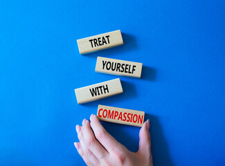 Treat yourself with compassion symbol. Concept words Treat yourself with compassion on wooden blocks. Beautiful blue background. Doctor hand. Medicine concept. Copy space.