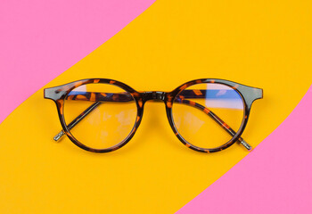 Stylish leopard-colored glasses on a colored background