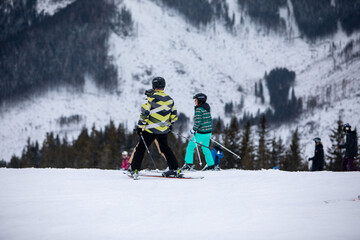 Fototapeta na wymiar Slovakia, Jasna - February 4, 2022: winter mountains view ski resort slopes people skiing and snowboarding