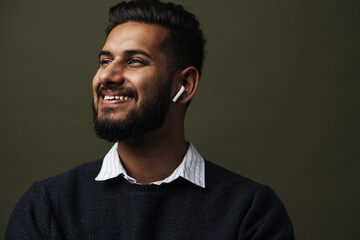 Close up portrait of smiling indian man with wireless earphones