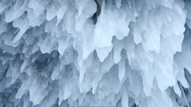 winter background. frozen winter ice icicles on the ceiling in the cave. icy frozen splashes, amazing winter pattern. lake baikal is a beautiful tourist attraction in siberia.