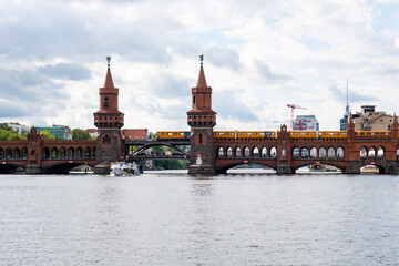 Oberbaum bridge with yellow tram in Berlin seen from the water.