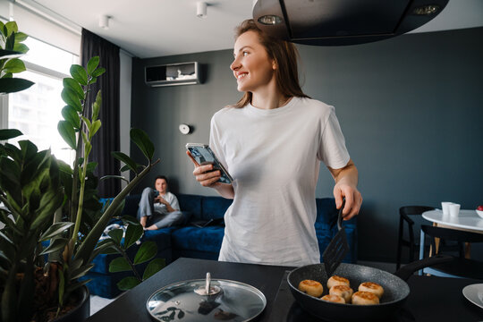 White young woman cooking breakfast while spending time with boyfriend