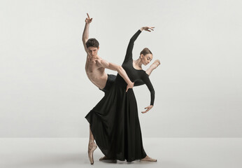 Young man and woman, ballet dancers performing isolated over grey studio background. Wonderful synergy © master1305