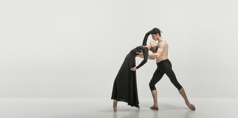 Young man and woman, ballet dancers performing isolated over grey studio background. Passionate relationship © master1305