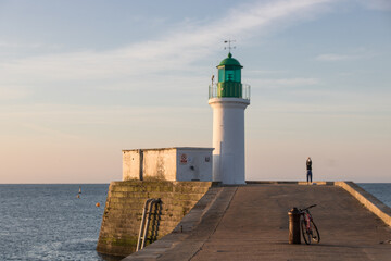 Fototapeta na wymiar la petite jetée et le phare vert à l'entrée du port des Sables d'Olonne en Vendée en France en été