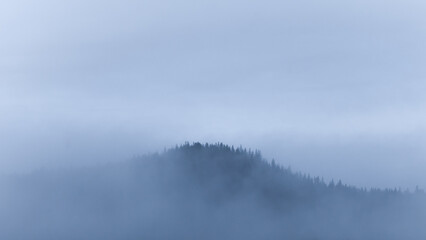 Small mountain covered in fog