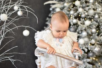 Naklejka premium Cute little baby against blurred lights on dark background. Christmas celebration