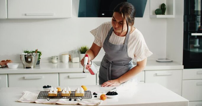 Confectioner prepares Delicious homemade desserts, on a rustic table, french meringue caramelized with a food torch. High quality 4k footage