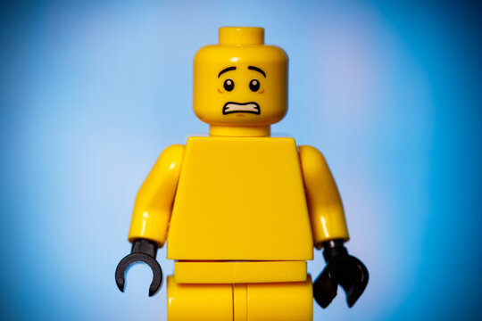 yellow lego figure with an evil face on a blue background with a vignette