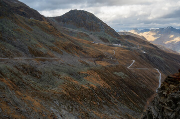 Alpine hills of rocks and stones. Some yellow mosses and lichens. Cloudy sky.