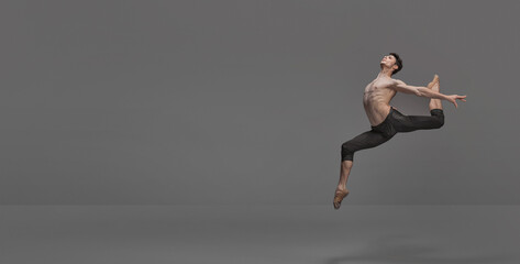 Portrait of young muscular man, ballet dancer performing on stage isolated over dark grey studio background. Flyer