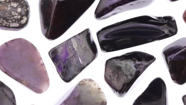 Sugilite rare jewel stones texture on white light background. Moving right seamless loop backdrop.