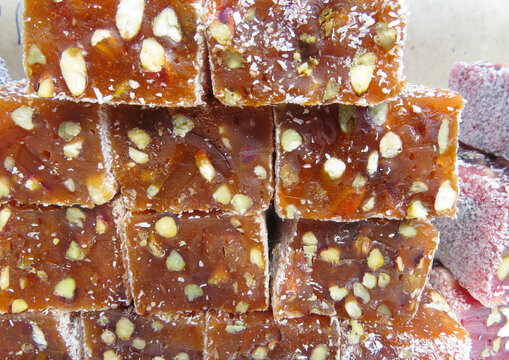Traditional Turkish delicacies. Varieties of Turkish Delight with Pistachio.Turkish delight sweet cubes background. Lokum sprinkled with sugarin , display at a street food market