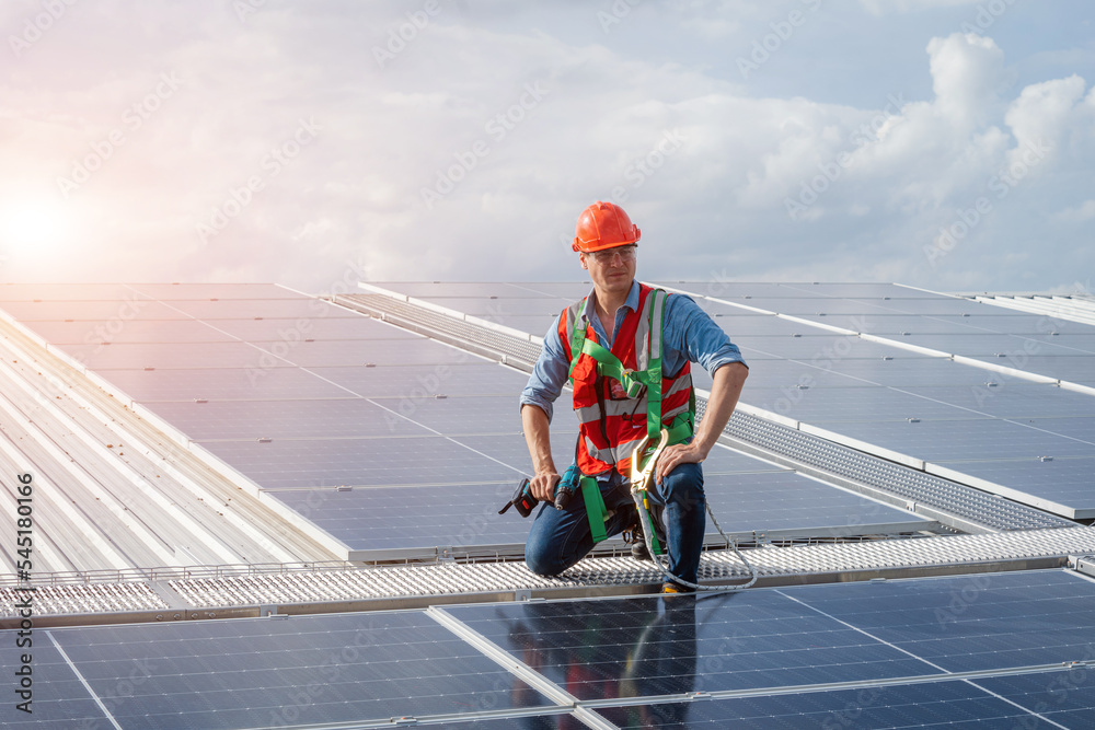 Aufkleber technician wearing safety harness belt using drill during installing the solar panels on roof struct