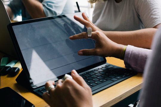 Cropped hand of female computer programmers using laptop in office