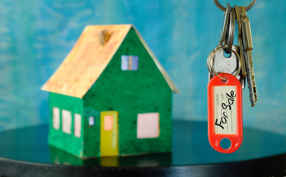 latchkey with key fob and blurred home in the back,buying house,real estate concept.Selective focus,free copy space