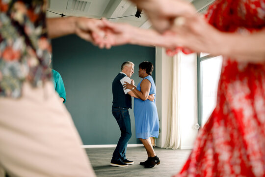 Full length of multiracial senior couple practicing dance in class