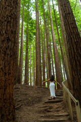 Young woman in white dress walking in the forest 