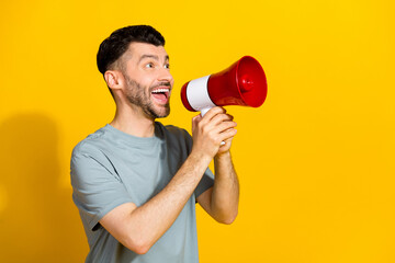 Profile side photo of cheerful man look empty space recommend new device shop black friday sale isolated on yellow color background