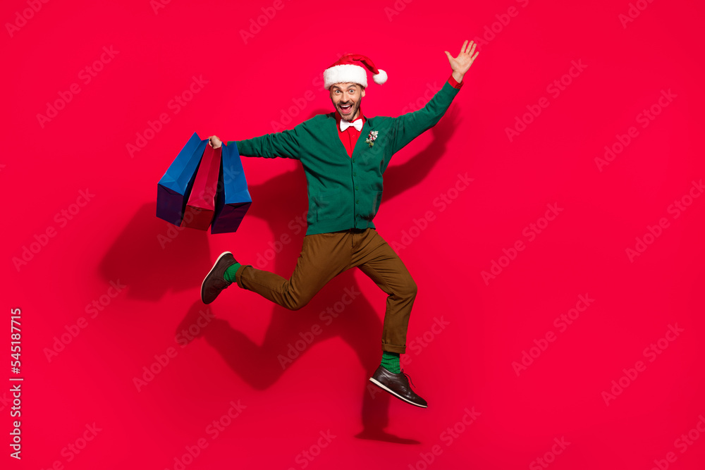 Sticker full length photo of excited charming guy dressed xmas green cardigan jumping rising noel gifts shop