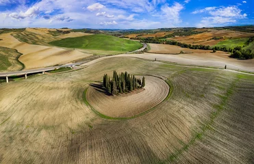 Schilderijen op glas Italy landscape. Amazing Tuscany scenery. Typical countryside with vast fields of Val d'Orcia famous beautiful valley. Aerial drone shot of circle cypresses trees, high angle view © Freesurf