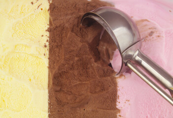 Ice-cream scoop close up and Neapolitan ice cream - vanilla, strawberry and chocolate.