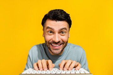 Closeup photo of young excited crazy positive man wear gray t-shirt typing wireless keyboard cool...