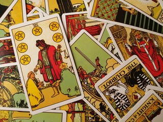 Picture of the Six of Pentacles tarot card from the original Rider Waite tarot deck with mixed tarot cards in the background