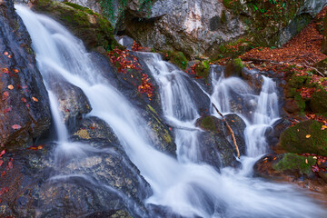 Autumnal landscape with waterfall in the mountains