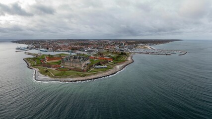 Aerial view of the Kronborg castle surrounded by nature and sea,with city panorama in the background
