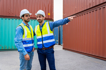 Two male engineers in a container shipping company Consulting to check the order for the container that is responsible