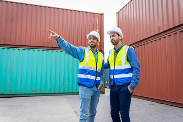 Two male engineers in a container shipping company Consulting to check the order for the container that is responsible