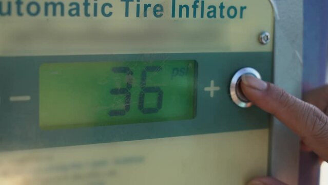 Automatic tire inflator. Hand press touch screen button on digital display of automatic tire inflator machine to set air pressure level.