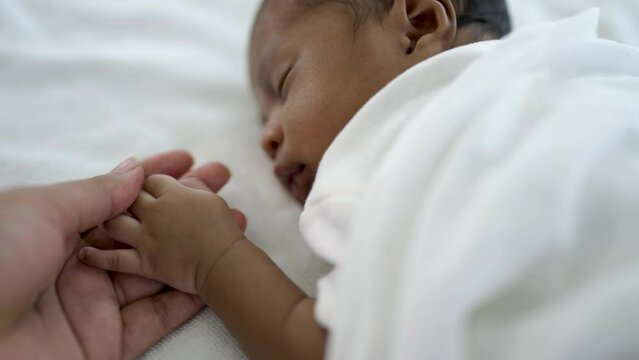 Parent hands holding newborn african black baby fingers, Close up mother's hand holding their new born baby. Together love family healthcare and medical, father's day and mother's day concept.