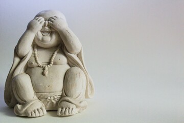 Closeup shot of a statue of a little Buddha with some shadows