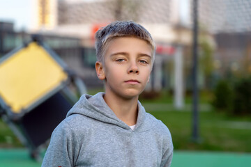 Portrait of confident teenage boy at outdoor sport courtyard looking at camera